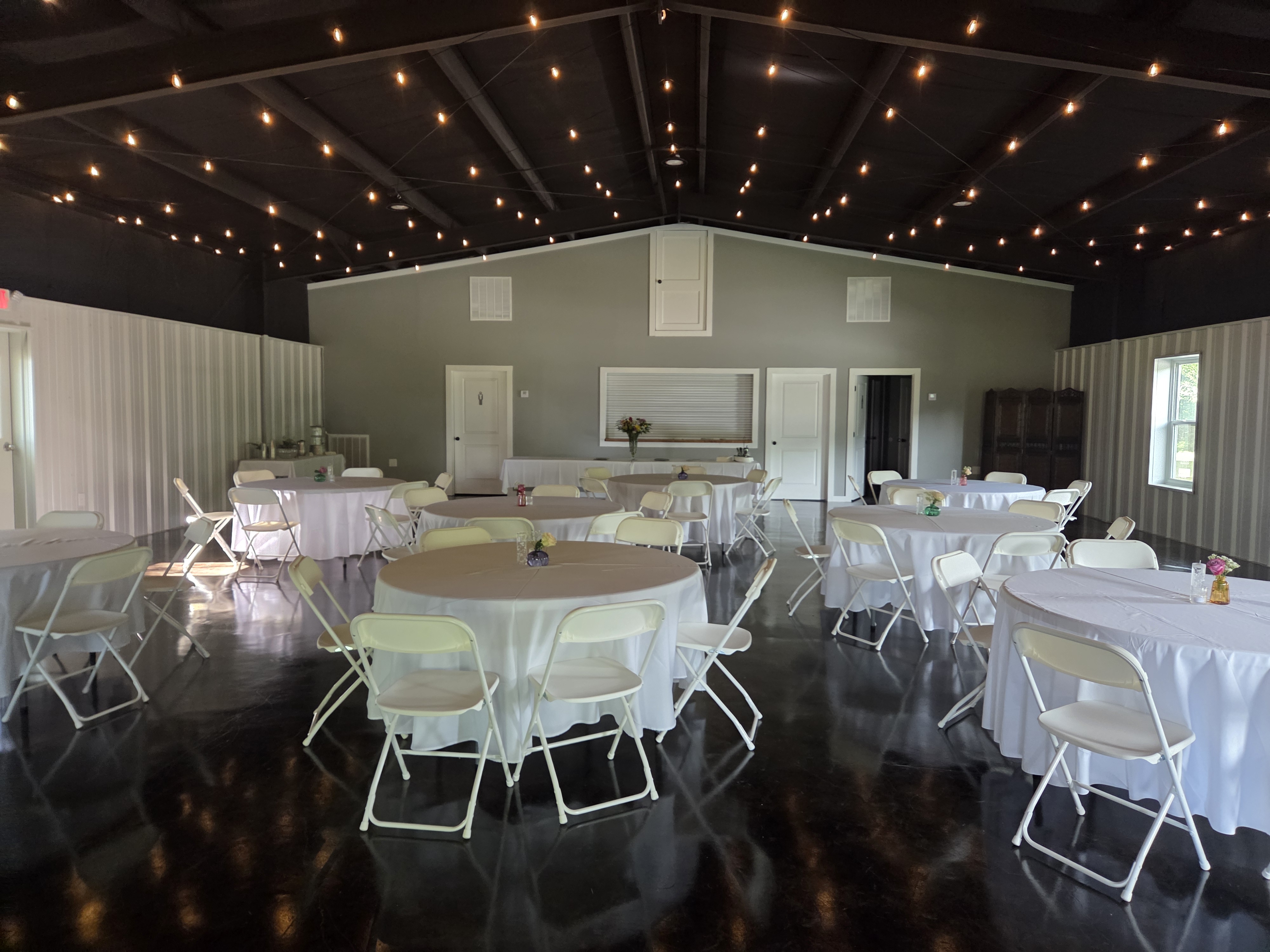 Reception hall with string lights and round tables
